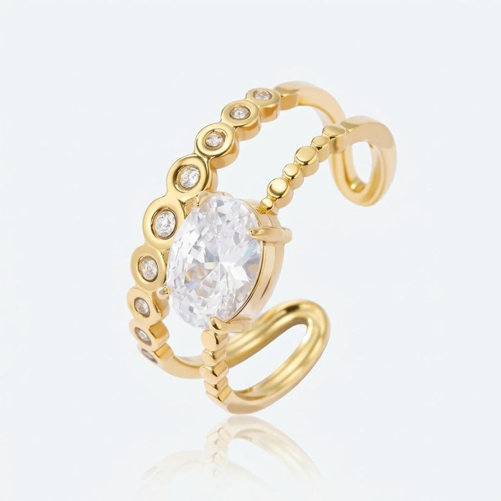Bague DIANA dorée fond gris — détail double anneau zircon ovale serti griffes acier inoxydable