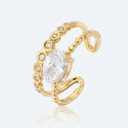 Bague DIANA dorée fond gris — détail double anneau zircon ovale serti griffes acier inoxydable