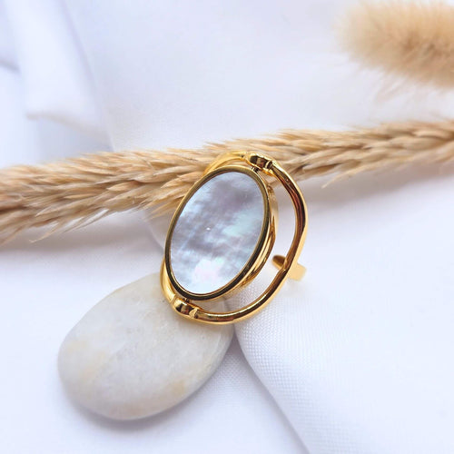 Bague ajustable coquille de nacre en acier inoxydable plaqué Or 18 carats. Le Bijou est rotatif et vous permet de choisir votre coloris selon votre humeur ou votre tenue. Rose clair ou blanc nacré.