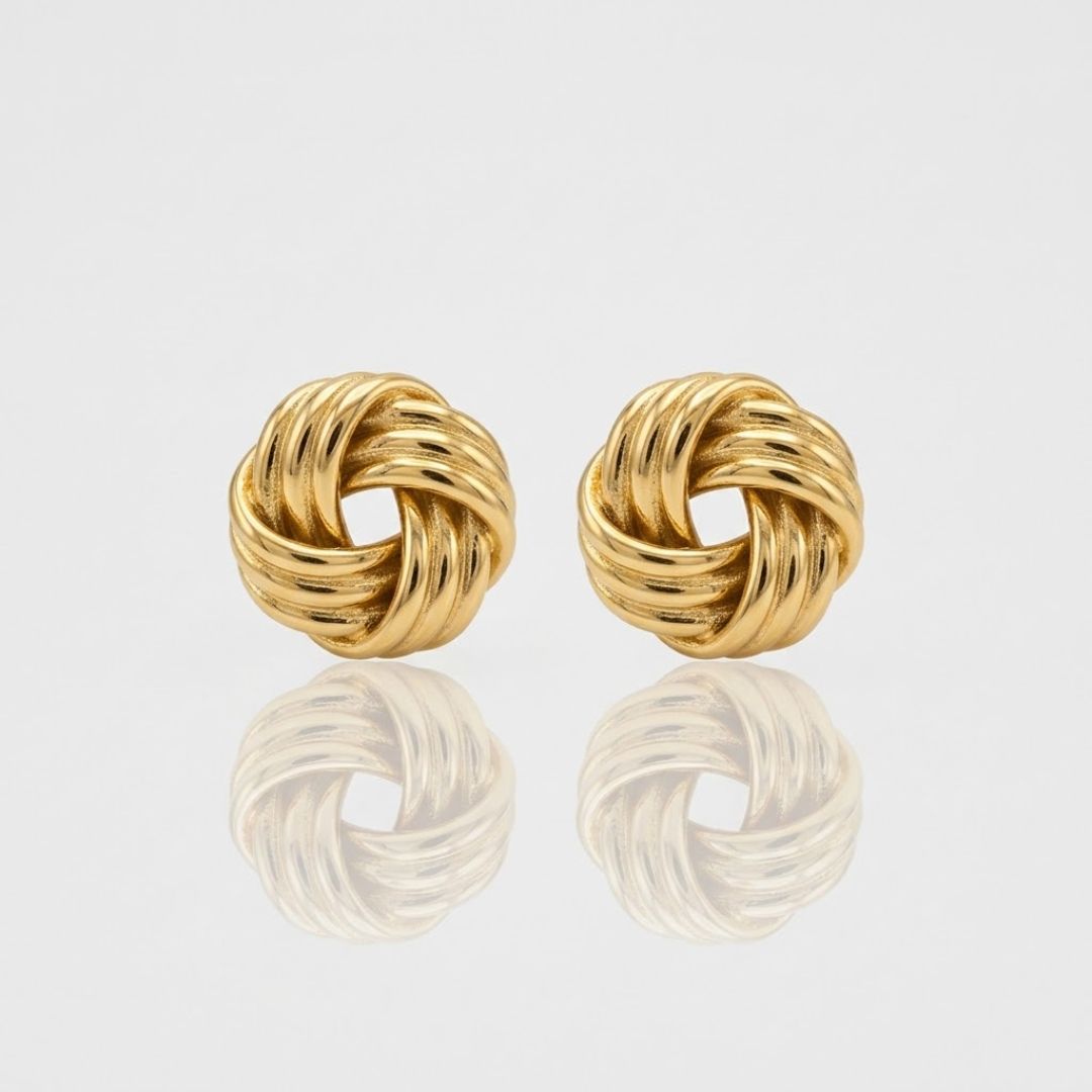 Boucles NOÉMI dorées fond gris — détail puce nœud tressé sculpté acier inoxydable