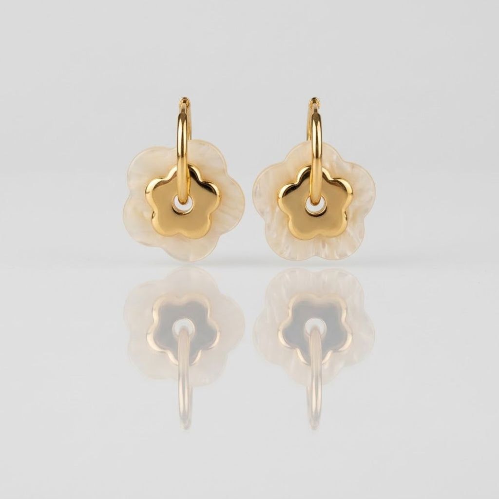 Boucles PAOLA dorées fond gris — détail double fleur nacre blanche et centrale dorée acier inoxydable