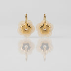 Boucles PAOLA dorées fond gris — détail double fleur nacre blanche et centrale dorée acier inoxydable