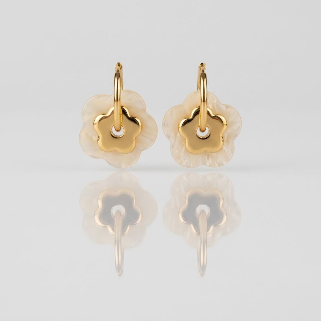 Boucles PAOLA dorées fond gris — détail double fleur nacre blanche et centrale dorée acier inoxydable