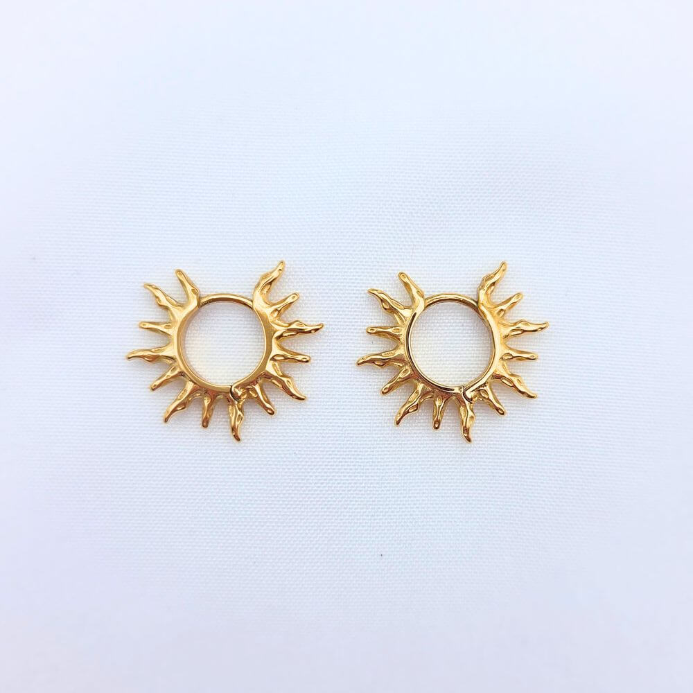 Vue détaillée des boucles d'oreilles HELIOS montrant la texture martelée du médaillon et le fermoir dormeuse sécurisé sur fond blanc.