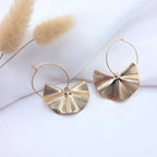 Créoles dorées avec pendentifs demi-lune texturés de style éventail sur fond blanc élégant.