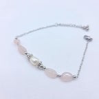 Bracelet NATTY en argent avec perles de quartz rose et perle d'eau douce centrale posé à plat.