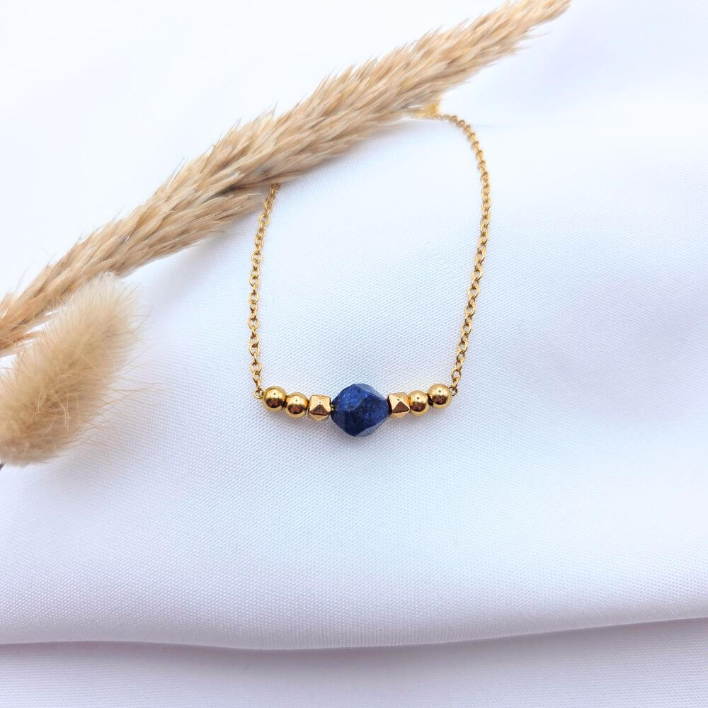 Bracelet en chaîne dorée avec perle centrale en Lapis-lazuli bleu profond et billes dorées.