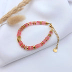 Bracelet Iris en Quartz Rose et acier doré posé sur un tissu blanc fluide avec des herbes de la pampa séchées.