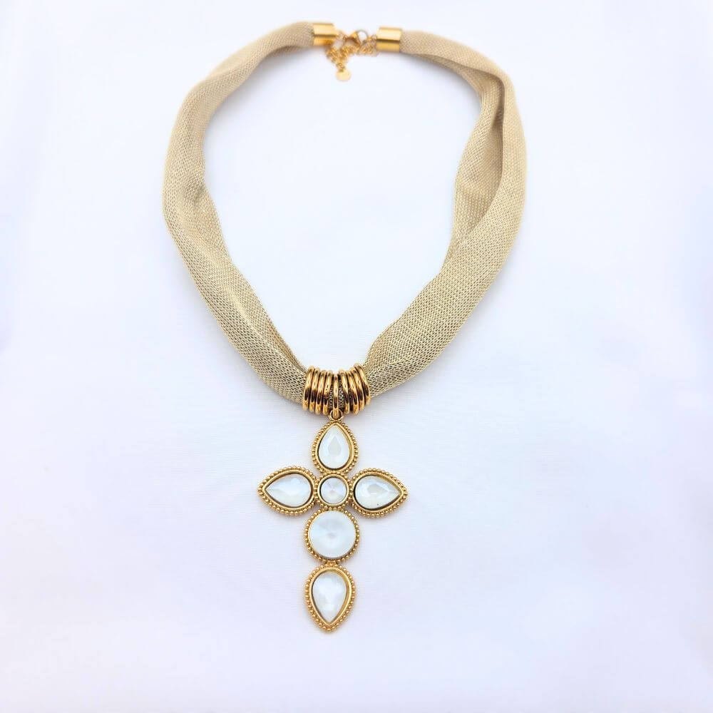 Détail du collier Cléo montrant le relief du pendentif médaillon et le travail de la maille corde en acier inoxydable doré sur fond blanc.