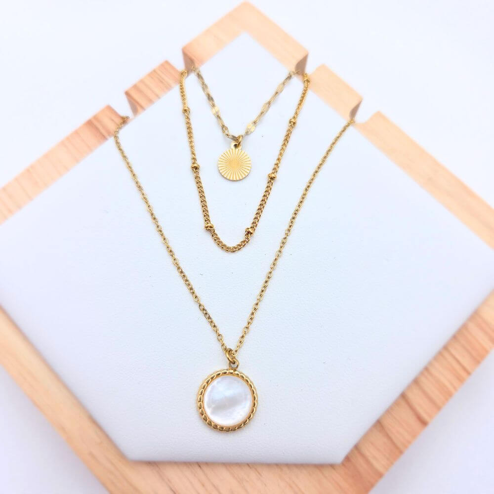 Vue détaillée du collier Rivage en acier inoxydable doré, mettant en avant la texture martelée et organique du pendentif sur fond blanc.