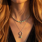 Exemple de 'layering' avec deux colliers en pierres naturelles. En haut, un collier de perles en Amazonite et fleur argentée. En bas, une chaîne argentée avec pendentif anneau en Howlite et goutte d'Amazonite.